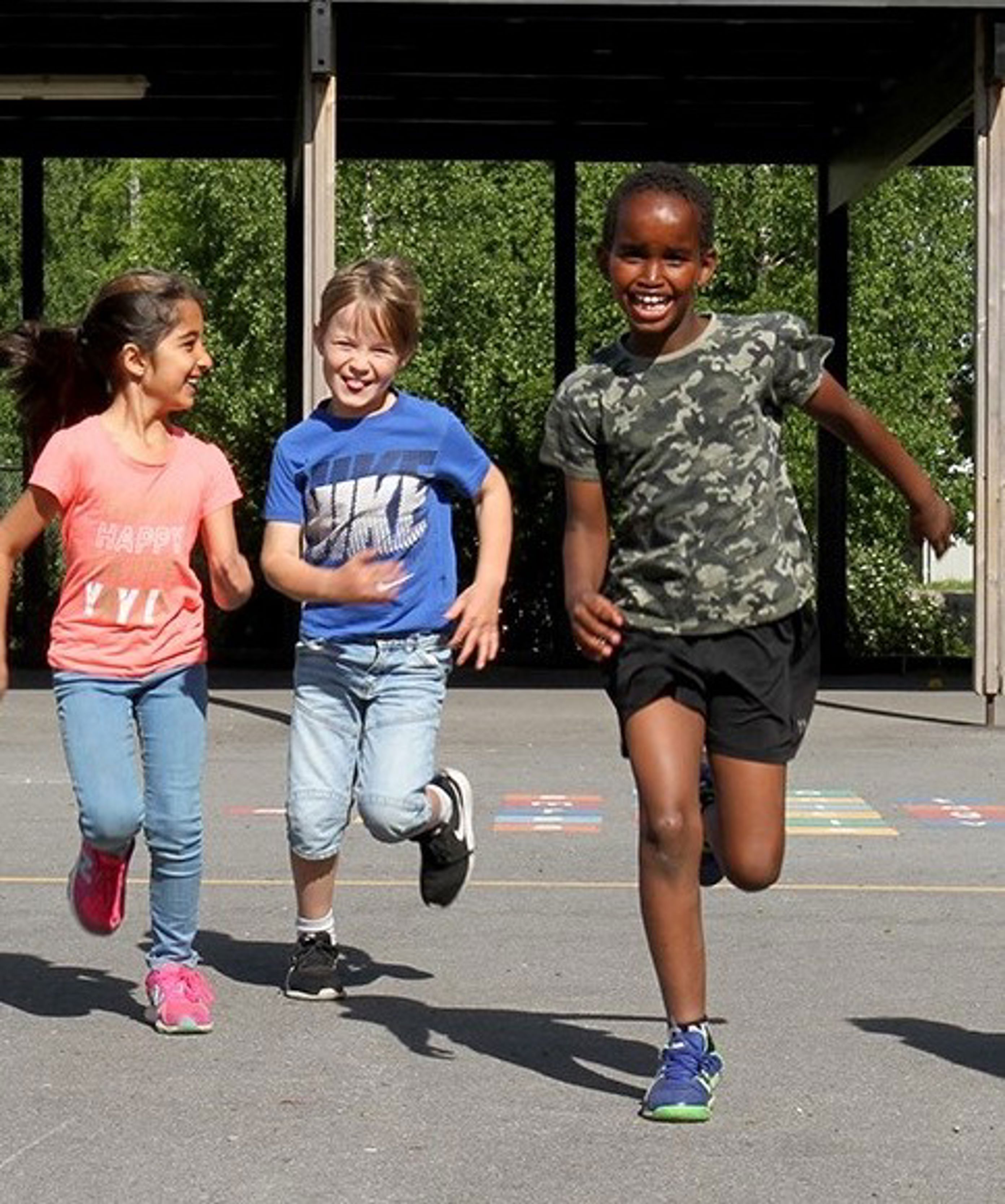Barn som løper i skolegård