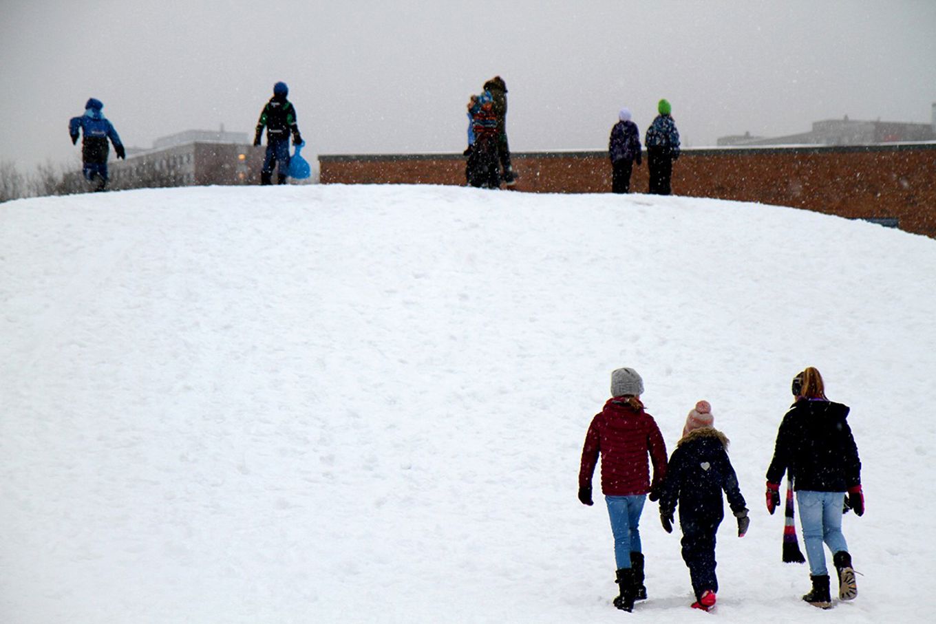 Barn leker i snø i skolegård
