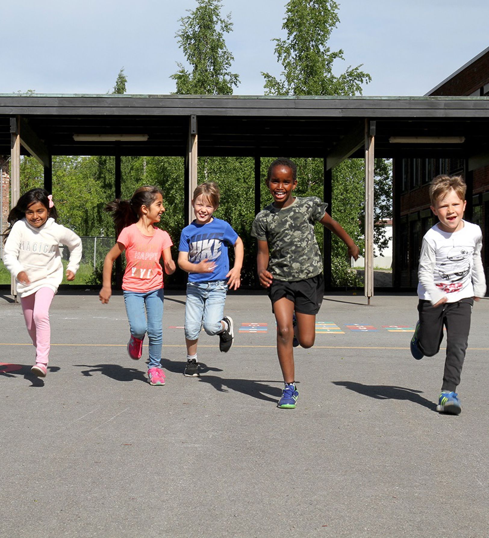 Barn som løper i skolegård